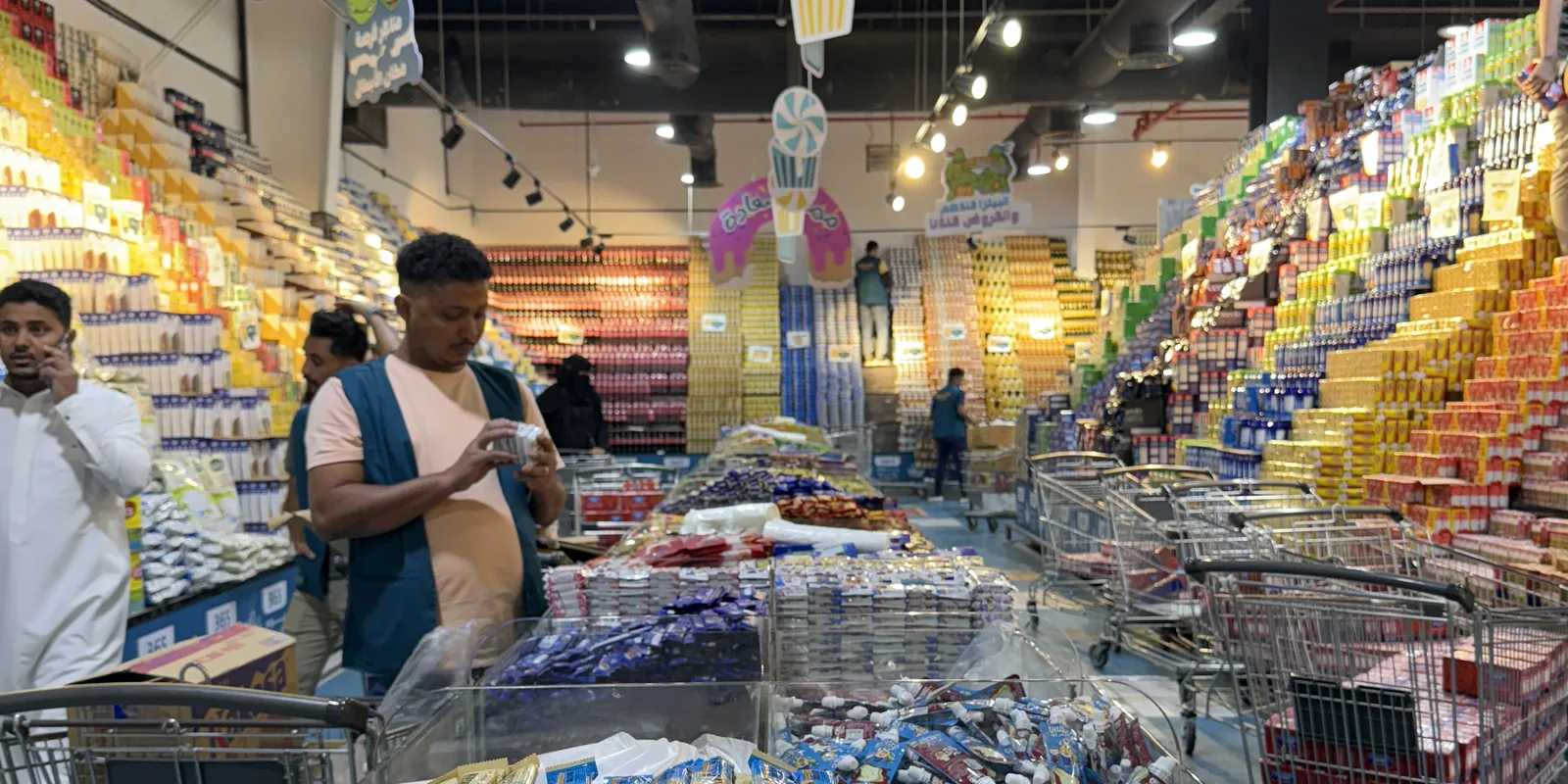 Busy Saudi hypermarket during a promotional season with mass product displays and shoppers